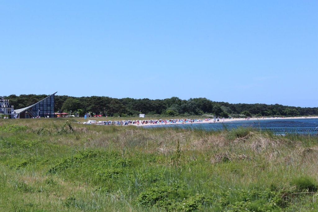 A beach with a modern building in the background.