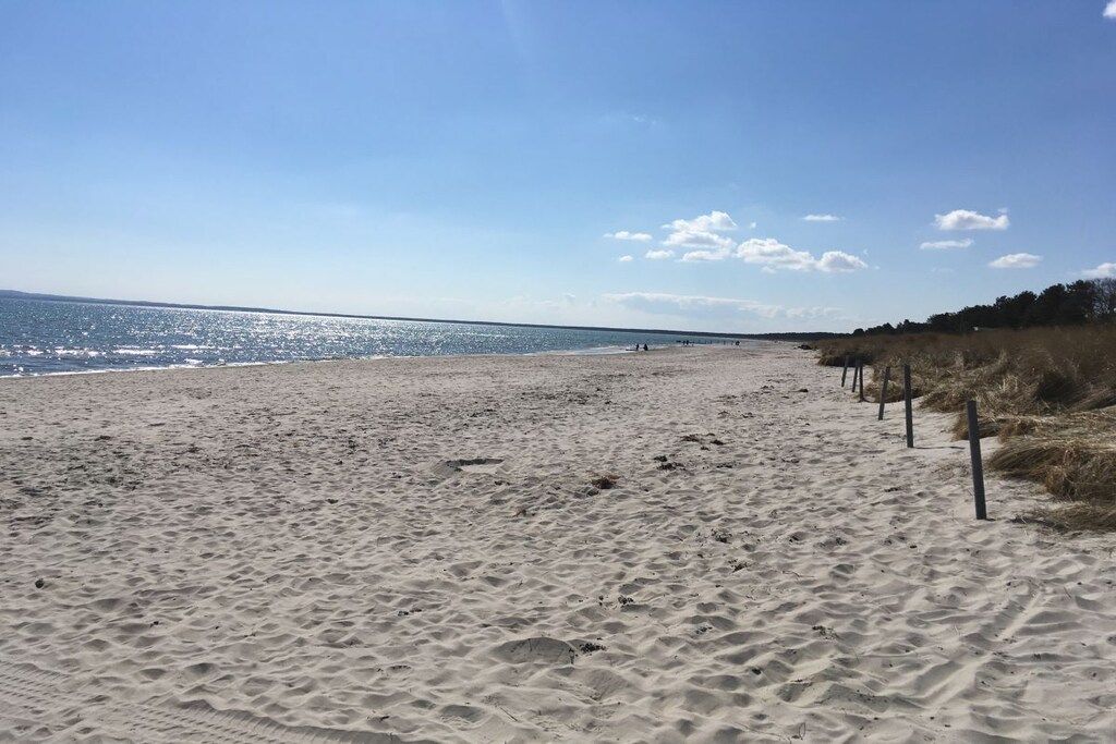 A sandy beach with a clear sky and calm sea.