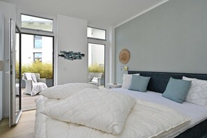 Een slaapkamer met een groot bed, een nachtkastje en uitzicht op het omliggende landschap.