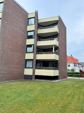 Ein mehrstöckiges Gebäude mit Balkonen und einer Ziegel Fassade.