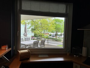 Ein Zimmer mit großem Fenster und Balkon mit Sitzmöbeln.