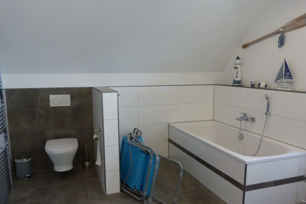 A bathroom with a toilet, a bathtub, and a shower.
