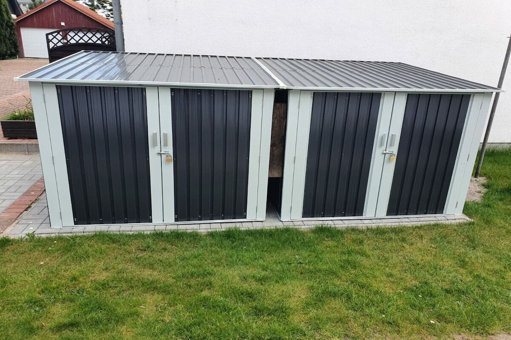 A two-sectioned shed with a metal roof and a door on each section.