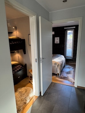 Ein Schlafzimmer mit einem Bett, einem Fenster und einer Tür zu einem anderen Raum.