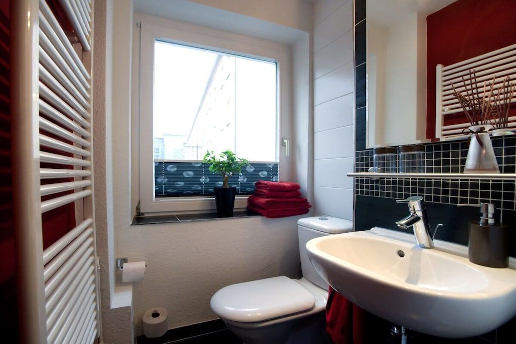A compact bathroom with a toilet, sink, and window.