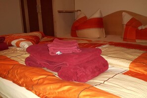 Habitación de hotel con cama, almohadas y una toalla doblada.