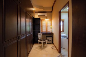 A narrow hallway with a wooden wardrobe, a white chair, and a small table with a vase. - Giant Palm Tree Views Retreat. Castle-Style Private Pool Villa. (Chalong)