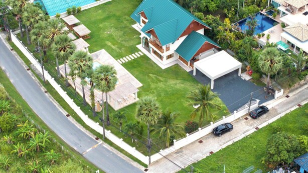 A residential property with a large house, a swimming pool, and a well-maintained lawn. - Giant Palm Tree Views Retreat. Castle-Style Private Pool Villa. (Chalong)