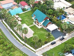 Ein Wohnhaus mit großem Garten, Schwimmbad und gepflegtem Rasen.