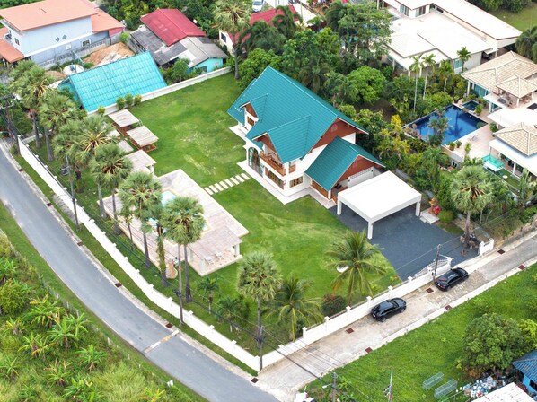 A residential property with a large house, a swimming pool, and a well-maintained lawn. - Giant Palm Tree Views Retreat. Castle-Style Private Pool Villa. (Chalong)