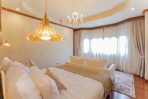 Um quarto espaçoso com uma cama grande, um sofá e um lustre.