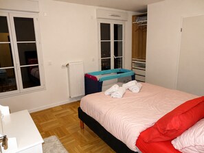 Un dormitorio con cama, radiador, ventana y armario.