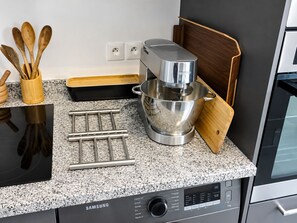 A kitchen with a Samsung appliance, wooden utensils, and a mixing bowl.