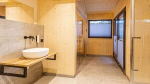 A wooden interior with a modern bathroom, including a sink and a window. - Superior Chalet # 2 with Sauna & Hot Tub (Turrach)