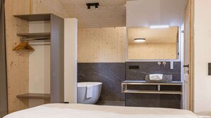 A modern bathroom with a toilet, sink, and mirror. - Superior Chalet #10 with Sauna & Hot Tub (Turrach)