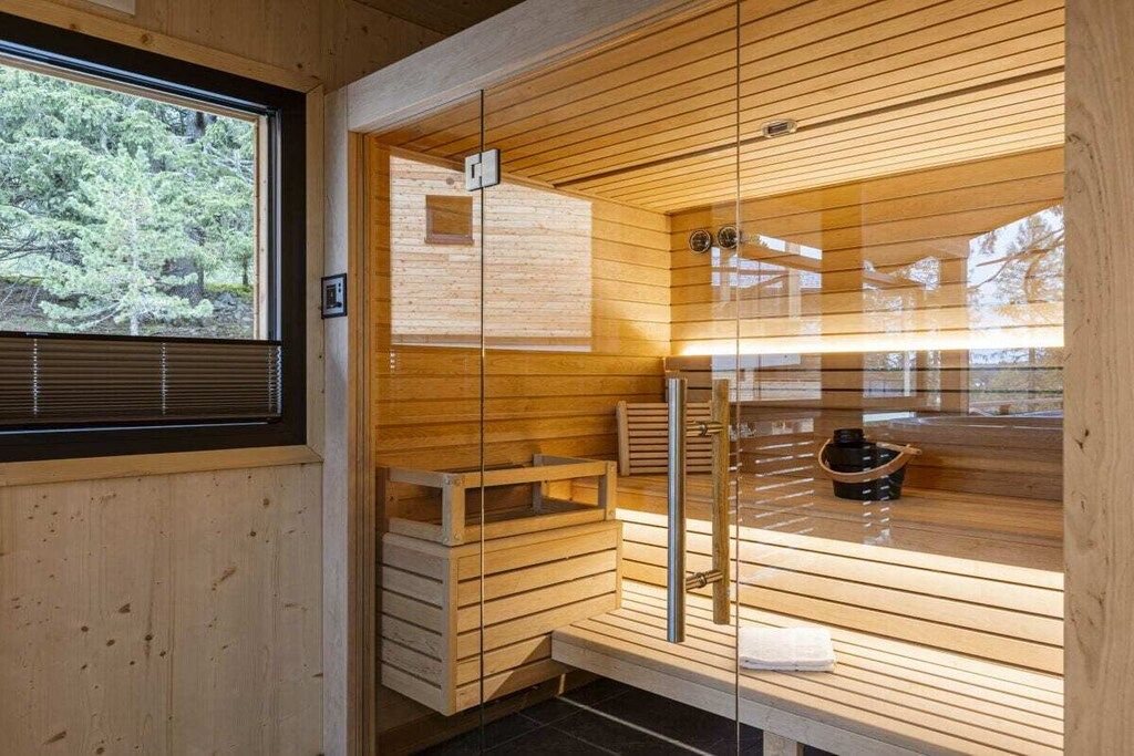 Una sauna con paredes de madera, un banco y una pequeña mesa.