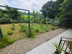 A garden with a gravel path, various plants, and a metal structure.