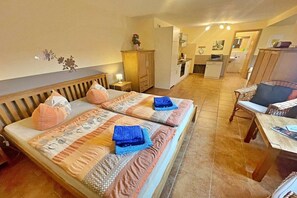 Ein Hotelzimmer mit einem Bett, einem Schreibtisch, einem Stuhl, einem Kleiderschrank und einer Küchenzeile.