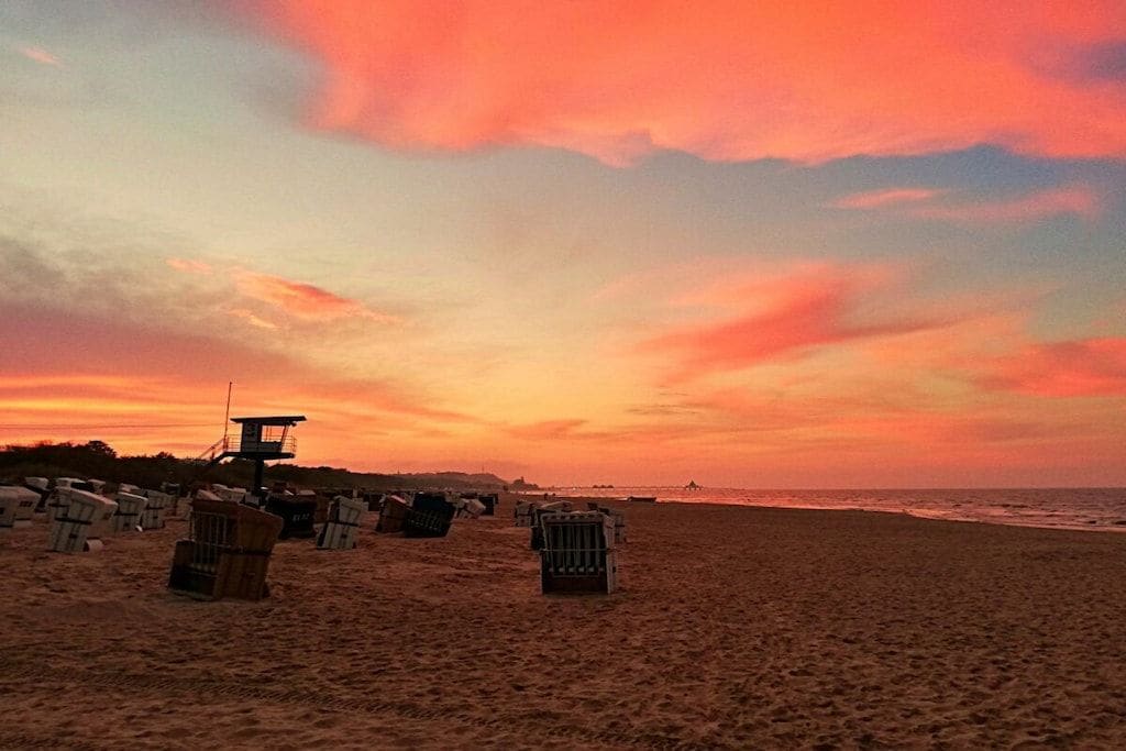 A beach with a lifeguard tower and several beach chairs.