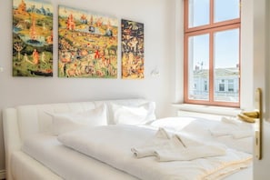 Ein Hotelzimmer mit einem großen Bett, einem Fenster mit Ausblick und drei Bildern an der Wand.