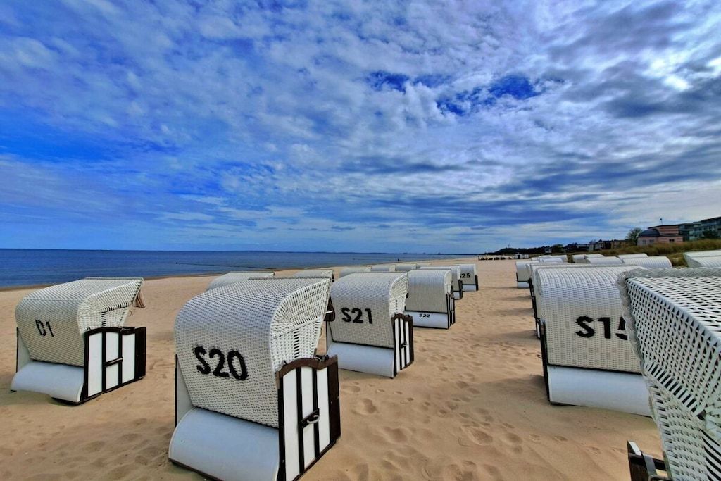 Des chaises de plage avec des étiquettes de prix, sur une plage de sable.