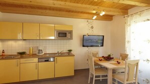 Una cucina con mobili gialli, un forno a microonde, una macchina da caffè e un tavolo da pranzo con sedie.