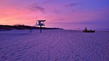 Ett livräddartorn på en strand, med en båt synlig på avstånd.