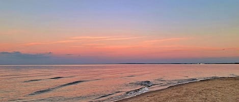 Une plage avec une mer calme et un ciel dégagé.