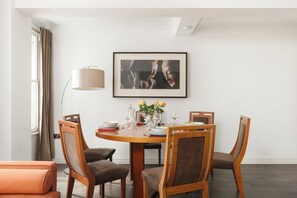 A dining area with a round table, four chairs, a vase with flowers, and a framed picture on the wall. - New! Spacious 1BR Flat | Marble Arch | Hyde Park (Greater London)