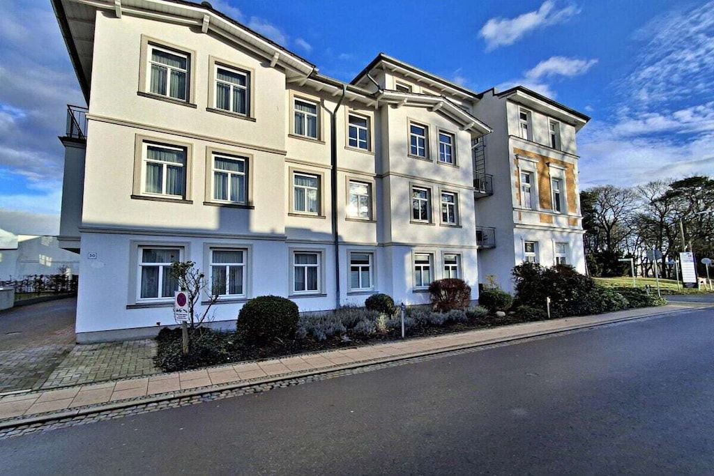 A multi-story building with a flat facade, large windows, and a gated entrance.