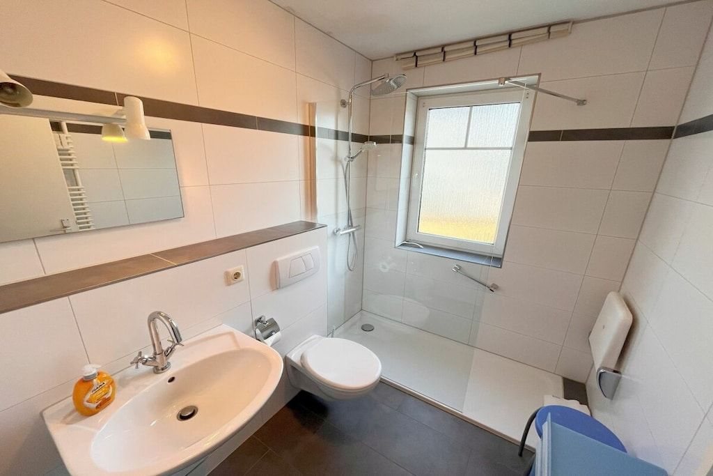 Een badkamer met een wastafel, toilet en douche.