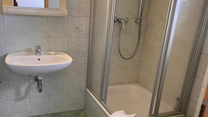 Un bagno con lavandino, doccia e WC.