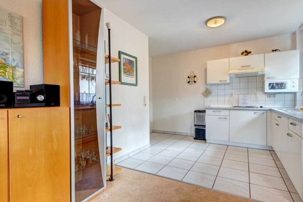 A modern kitchen with white cabinets, a microwave, and a dishwasher.