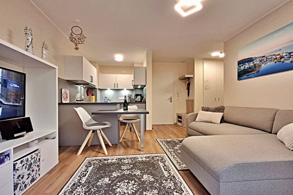 Een moderne woonruimte met keuken, eethoek en zithoek.