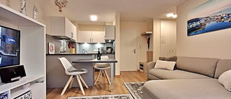 Een moderne woonruimte met keuken, eethoek en zithoek.