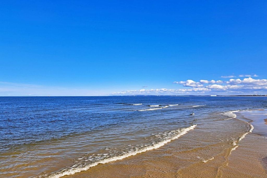 Ein Strand mit klarem, blauem Wasser und einem sandigen Ufer.