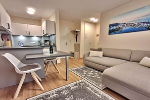 A modern living space with a kitchen, dining area, and a sofa. - Schloonseevillen Bansin Apartment 15 (Bansin (Seebad))