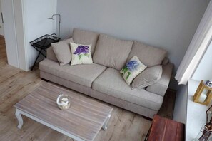 A living room with a striped sofa, a small table, and a floor lamp. - Hohenzollern Castle - Apartment 11 (Ahlbeck (Seebad))