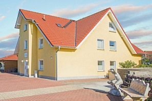 Ein zweigeschossiges Gebäude mit rotem Ziegeldach und einer gelben Fassade.