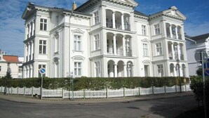 Un grande edificio neoclassico, bianco, con diversi piani e una facciata simmetrica.