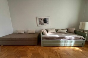 Huoneessa on sänky, sohva ja seinällä kehystetty taulu.