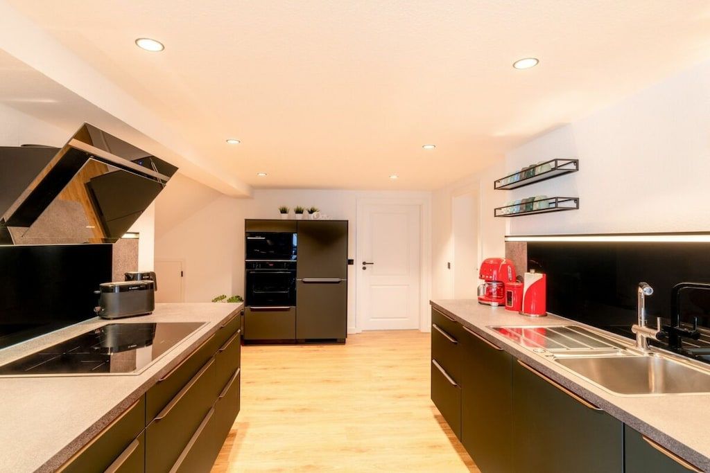 A modern kitchen with a central island, built-in appliances, and a sleek design.