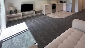 Un apartament modern amb un saló, una cuina i una zona de menjador.