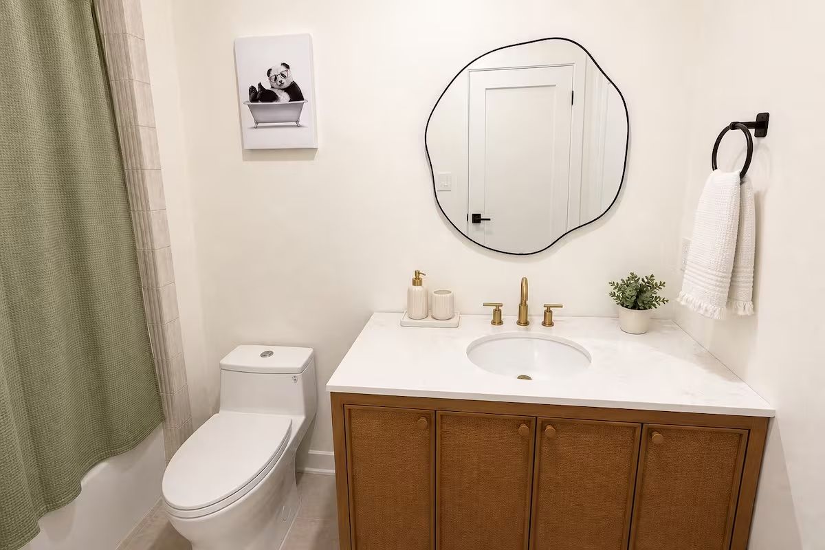 A bathroom with a toilet, a sink with a mirror, and a towel rack.