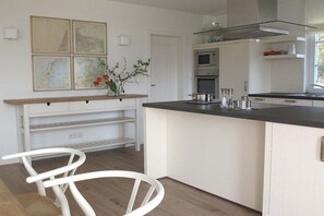 Eine moderne Küche mit weißen Schränken, einer schwarzen Arbeitsplatte und einem eingebauten Backofen.