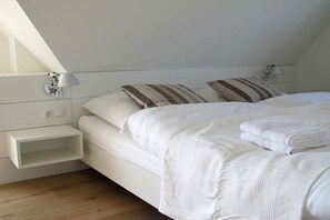 Ein Schlafzimmer mit einem Bett, Kissen, einem Nachttisch und einer Lampe.