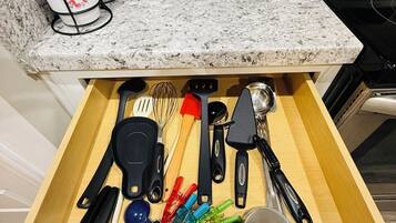 Un cajón de cocina con varios utensilios y artículos de cocina.