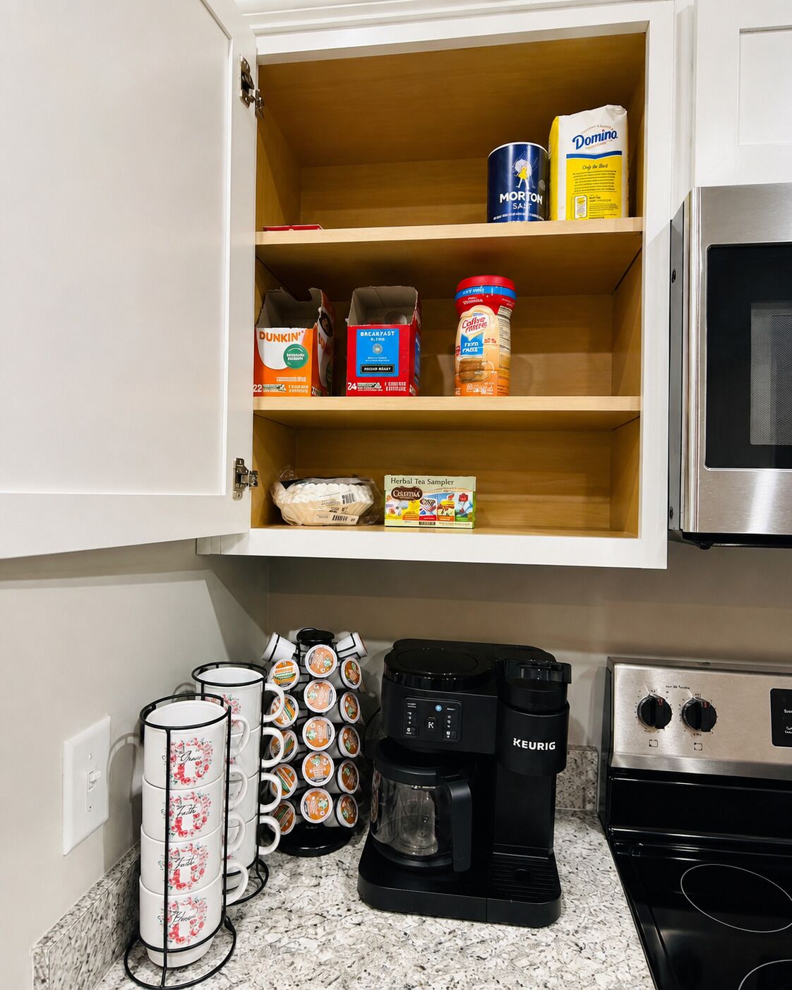 A kitchen with a coffee maker, a kettle, and a microwave.