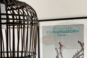 A framed poster of a swimming pool with the text 'OSTSEEBAD KÜHLUNGSBORN Seebrücke'. - Holiday apartment with 1 bedroom (Kühlungsborn)