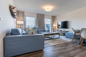 Een moderne woonkamer met een bank, een salontafel en een televisie.